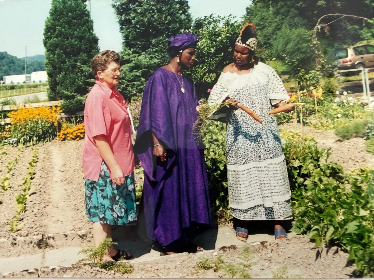 Trudy L&ouml;tscher f&uuml;hrt Pendo und Fatumata aus Burkina Faso durch ihren Garten.