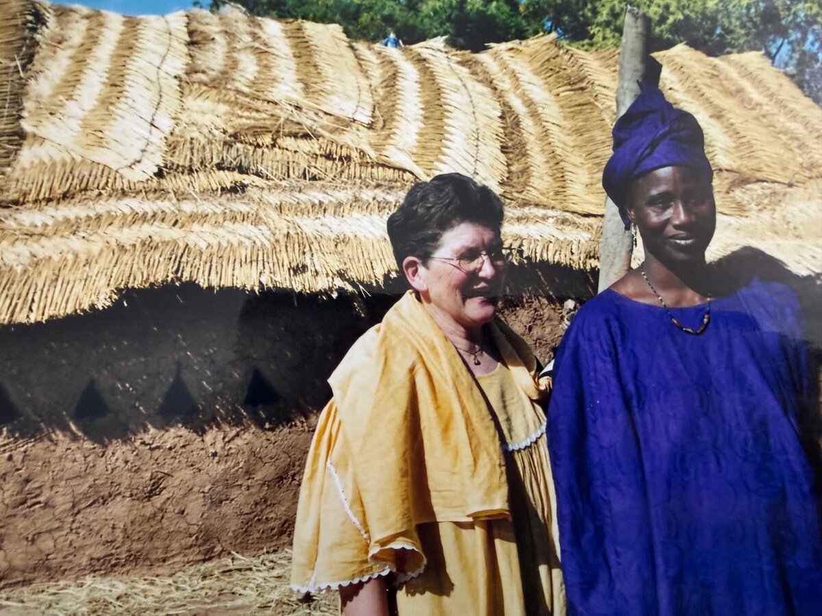 Trudy mit Pendo in Burkino Faso vor dem neu errichteten Hangar zum Aufbewahren des Heus f&uuml;r die Trockenzeit.